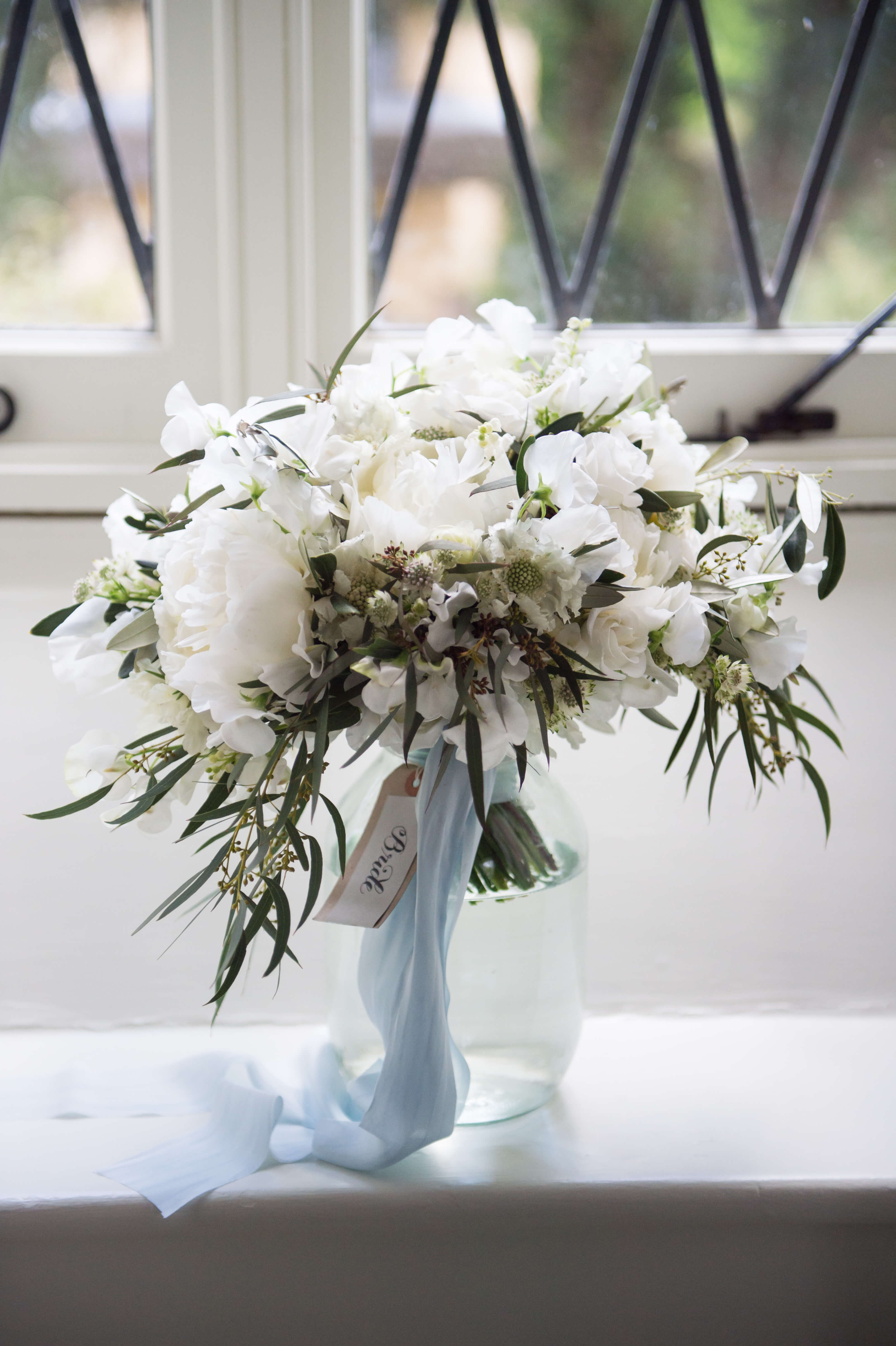 bridal bouquet with blue ribbon by passion florist